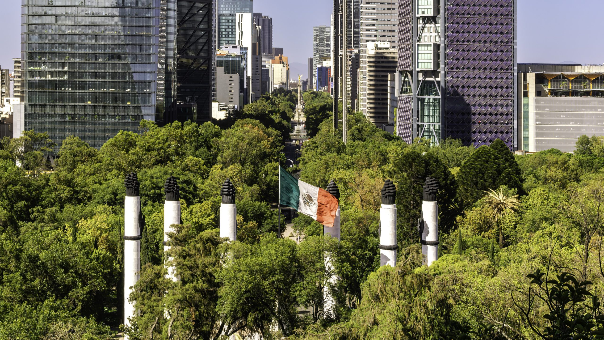 Aerial shot of Chapultepec Park with skyscrapers and the Mexican flag